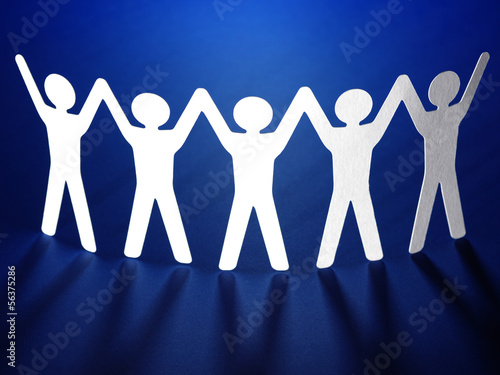 Photo: Group of paper people holding hands. Group of paper people holding hands.