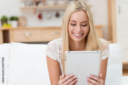 Photo: lächelnde junge frau liest ein ebook lächelnde junge frau liest ein ebook