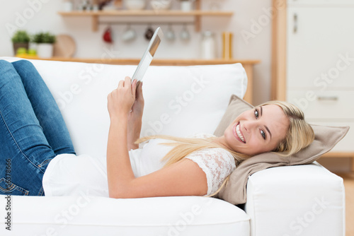Photo: lächelnde junge frau mit tablet-pc zu hause lächelnde junge frau mit tablet-pc zu hause