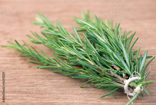 Photo: Bunch of rosemary on a rustic wood Bunch of rosemary on a rustic wood