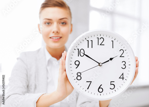 Photo: attractive businesswoman with white clock attractive businesswoman with white clock