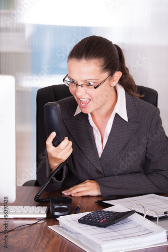 Photo: Angry Businesswoman Shouting On Telephone in office Angry Businesswoman Shouting On Telephone in office