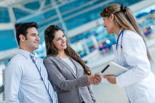 Photo: Doctor handshaking a couple Doctor handshaking a couple