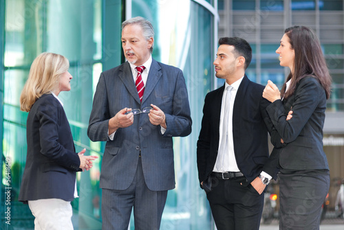 Photo: Group of business people stood outside building Group of business people stood outside building