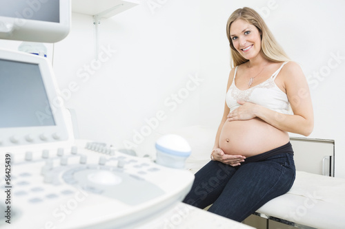 Photo: Happy Pregnant Woman By Ultrasound Machine Happy Pregnant Woman By Ultrasound Machine