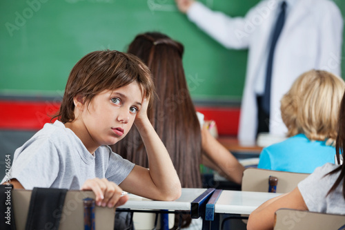 Photo: Portrait Of Little Boy Leaning At Desk Portrait Of Little Boy Leaning At Desk