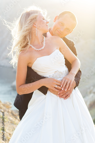 Photo: Couple in love young bride and groom dressed in white Couple in love young bride and groom dressed in white