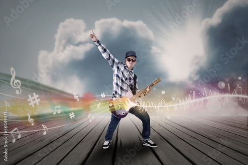 Photo: Artist perform guitar instrument under blue sky Artist perform guitar instrument under blue sky