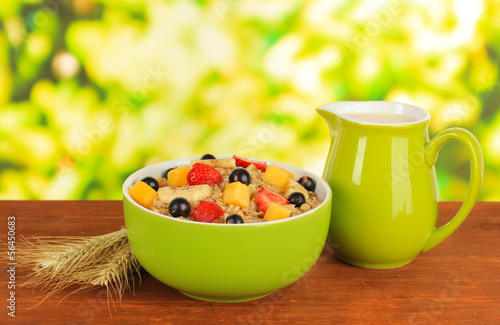 Photo: Oatmeal with fruits on table on bright background Oatmeal with fruits on table on bright background