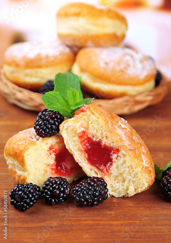 Photo: Tasty donuts with berries on wooden table Tasty donuts with berries on wooden table
