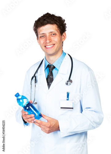 Photo: Portrait of a smiling male doctor holding bottle of water on whi Portrait of a smiling male doctor holding bottle of water on whi