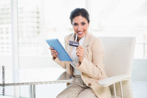Photo: Excited businesswoman shopping online with tablet pc Excited businesswoman shopping online with tablet pc