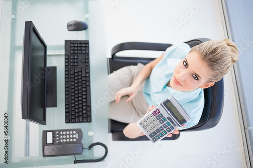 Photo: Overhead view of elegant businesswoman showing calculator Overhead view of elegant businesswoman showing calculator