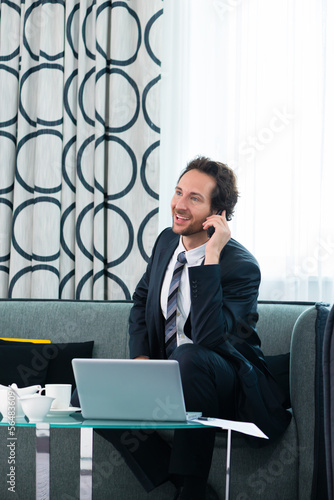 Photo: businessman in hotel is on the phone businessman in hotel is on the phone