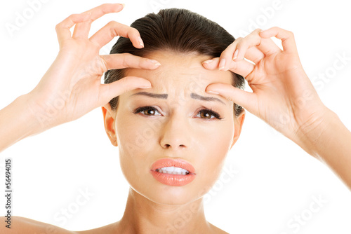 Photo: Woman checking her wrinkles on her forehead Woman checking her wrinkles on her forehead