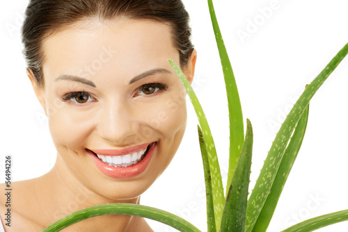 Photo: Young beautiful woman's face and aloe vera. Young beautiful woman's face and aloe vera.