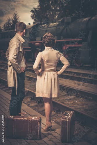 Photo: Beautiful couple with suitcases on train station Beautiful couple with suitcases on train station