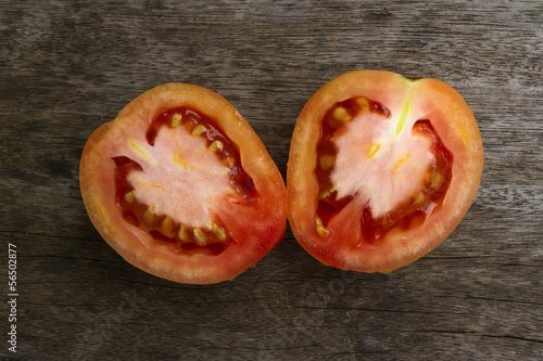 Photo: Slided Tomato on the wooden texture. Slided Tomato on the wooden texture.