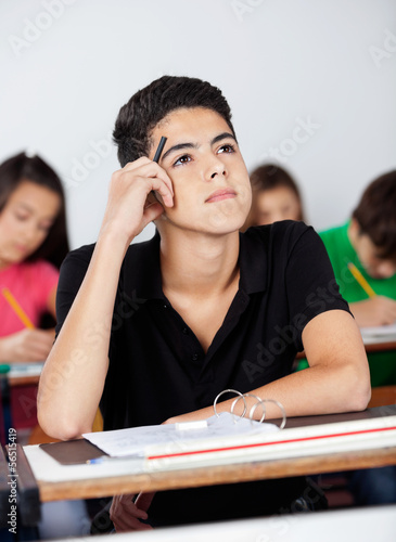 Photo: Thoughtful Teenage Schoolboy Leaning At Desk Thoughtful Teenage Schoolboy Leaning At Desk