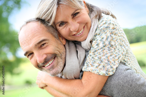 Photo: Senior man giving piggyback ride to woman Senior man giving piggyback ride to woman