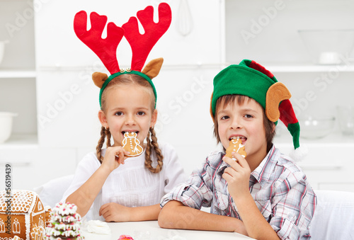 Photo: Kids with christmas hats eating gingerbread cookies Kids with christmas hats eating gingerbread cookies