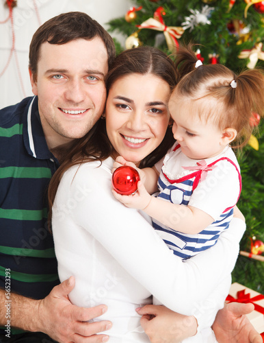 Photo: Happy family with near the Christmas tree Happy family with near the Christmas tree