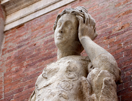Photo: statue with headaches with red brick background statue with headaches with red brick background