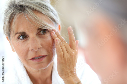 Photo: Senior woman applying anti-wrinkles cream Senior woman applying anti-wrinkles cream