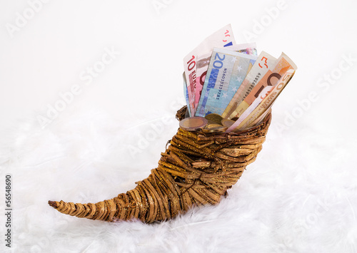 Photo: cornucopia - horn of plenty. standing on a bed of feathers. cornucopia - horn of plenty. standing on a bed of feathers.