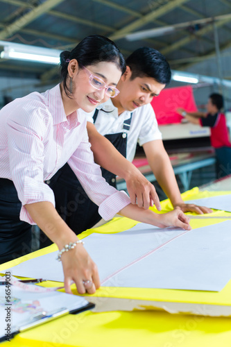 Photo: Asian production manager and designer in factory Asian production manager and designer in factory