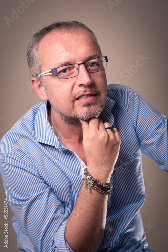Photo: Middle age man close up portrait against dark background. Middle age man close up portrait against dark background.