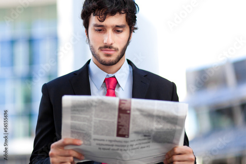 Photo: Business man reading a newspaper Business man reading a newspaper