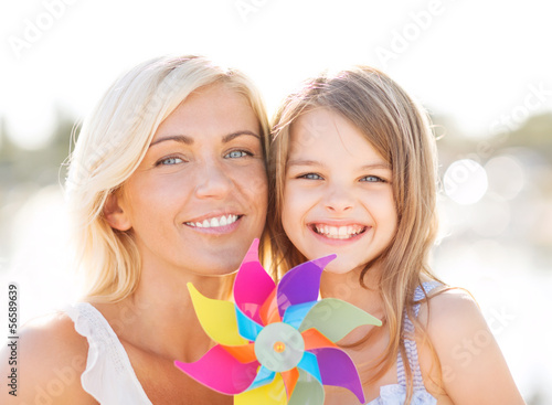 Photo: happy mother and child girl with pinwheel toy happy mother and child girl with pinwheel toy