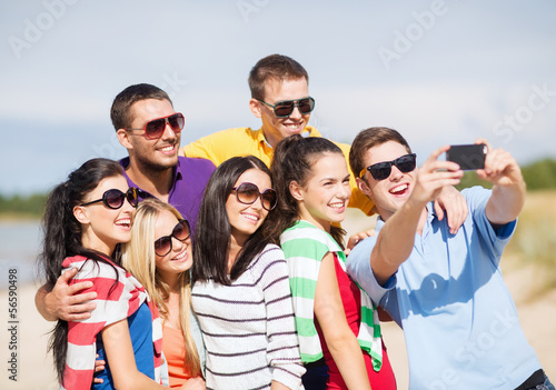 Photo: group of friends taking picture with smartphone group of friends taking picture with smartphone