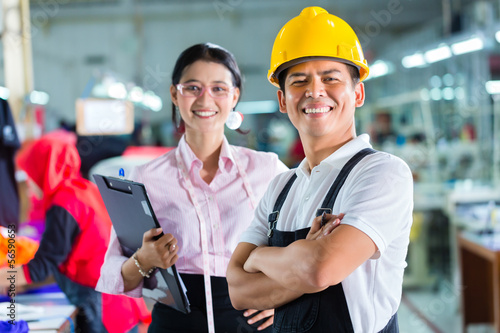 Photo: Production manager and designer in Asian factory Production manager and designer in Asian factory