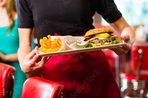 Photo: Waitress serving in American diner or restaurant Waitress serving in American diner or restaurant