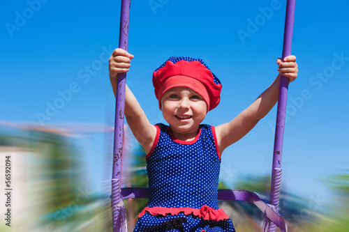 Photo: Little girl swinging on a swing. Little girl swinging on a swing.