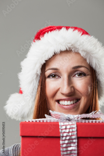 Photo: Woman in a Santa hat with a Christmas gift Woman in a Santa hat with a Christmas gift