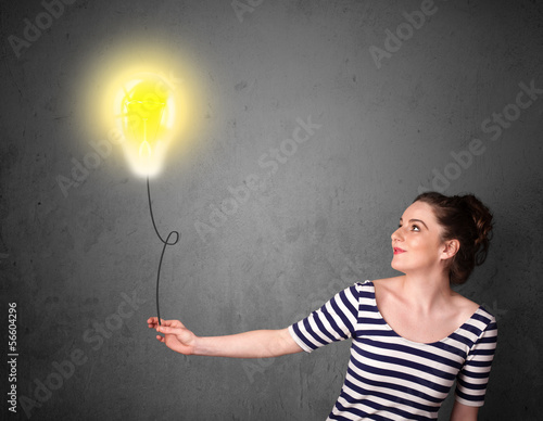 Photo: Woman holding a lightbulb balloon Woman holding a lightbulb balloon