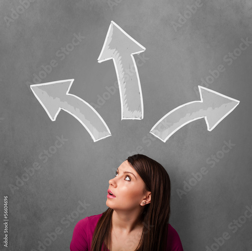Photo: Young woman thinking with arrows above her head Young woman thinking with arrows above her head