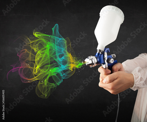 Photo: Painter working with airbrush and paints colorful paint Painter working with airbrush and paints colorful paint