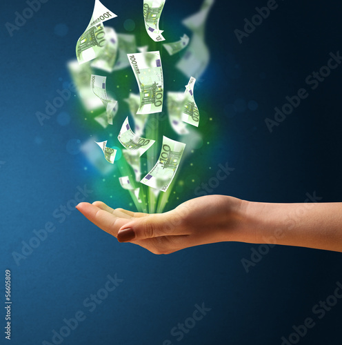 Photo: Glowing money in the hand of a woman Glowing money in the hand of a woman