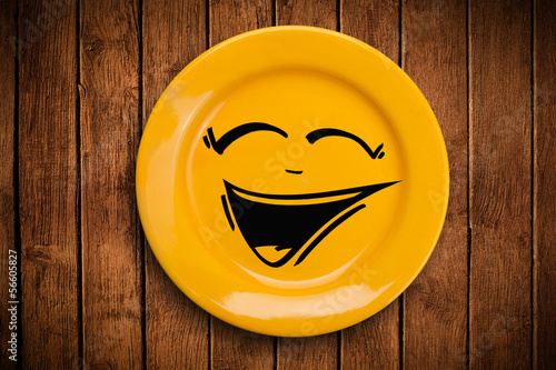 Photo: Happy smiley cartoon face on colorful dish plate Happy smiley cartoon face on colorful dish plate