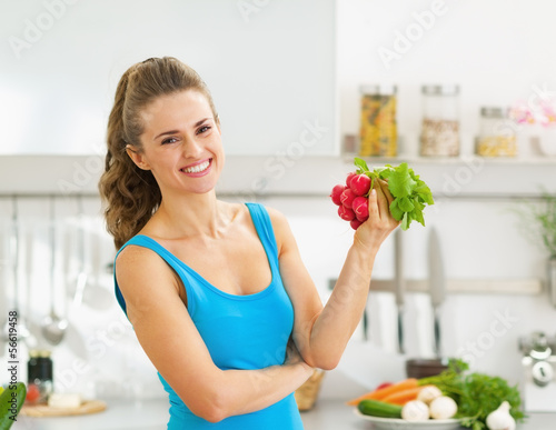Photo: Happy young woman holding bunch of radishes Happy young woman holding bunch of radishes