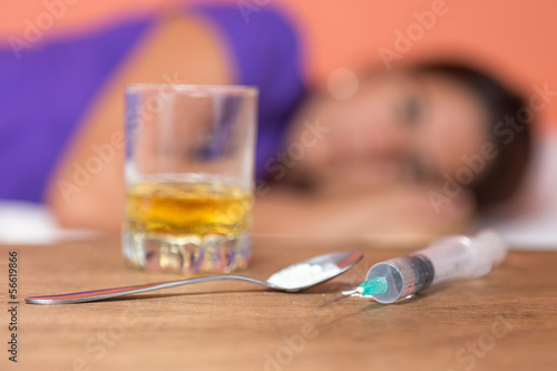 Photo: Female addict with drugs,syringe and alcohol Female addict with drugs,syringe and alcohol