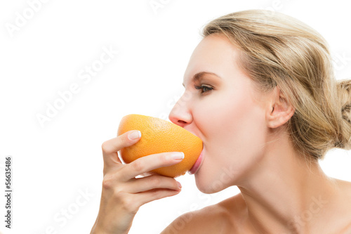 Photo: Young girl biting a juicy grapefruit Young girl biting a juicy grapefruit