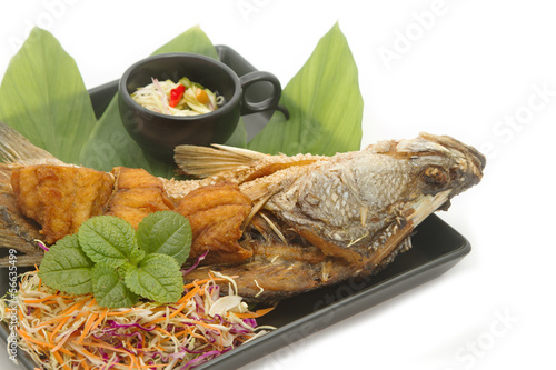 Photo: Fish fried with spicy mango salad in the black plate Fish fried with spicy mango salad in the black plate