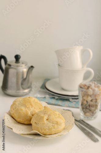 Photo: Breakfast with eclair on light background Breakfast with eclair on light background