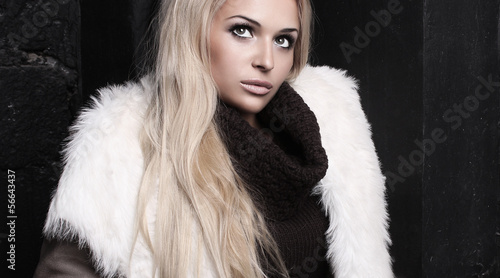 Photo: Beautiful blond woman in fur near bricks wall.winter fashion. Beautiful blond woman in fur near bricks wall.winter fashion.