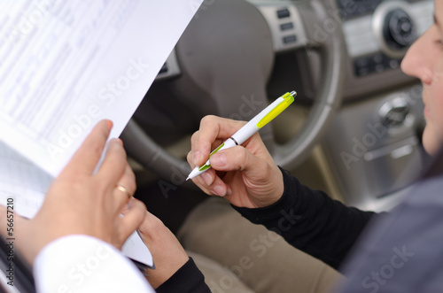 Photo: Woman driver signing paperwork Woman driver signing paperwork